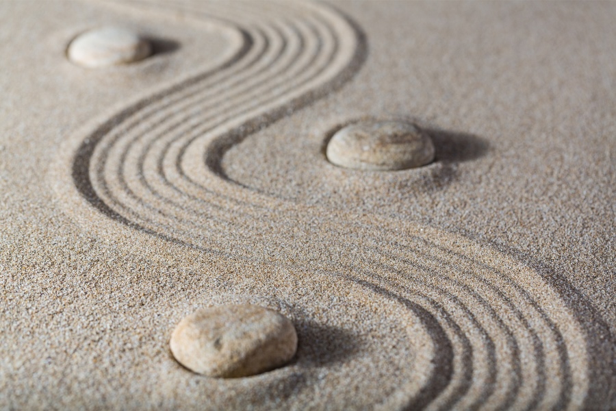 Image of a path through the sand with rocks on the sides.